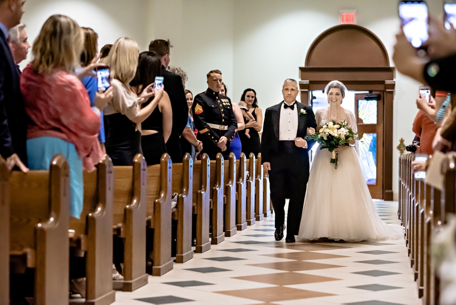 A bride and her father walking down the isle in philadelphia.